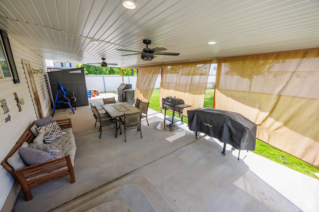 Fenced backyard featuring a storage shed, outdoor dining space, grilling area, a patio, and an outdoor living space