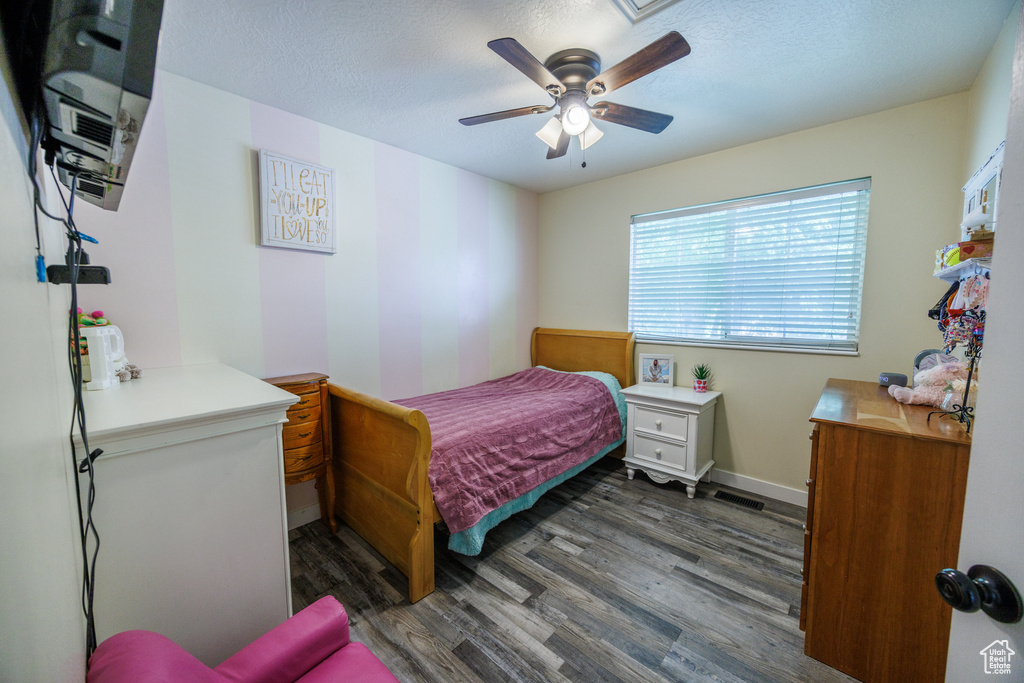 Bedroom featuring wood finished floors, a ceiling fan, and a textured ceiling