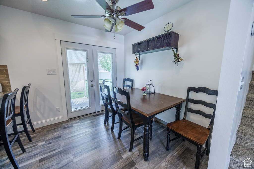 Dining space featuring wood finished floors, ceiling fan, and french doors
