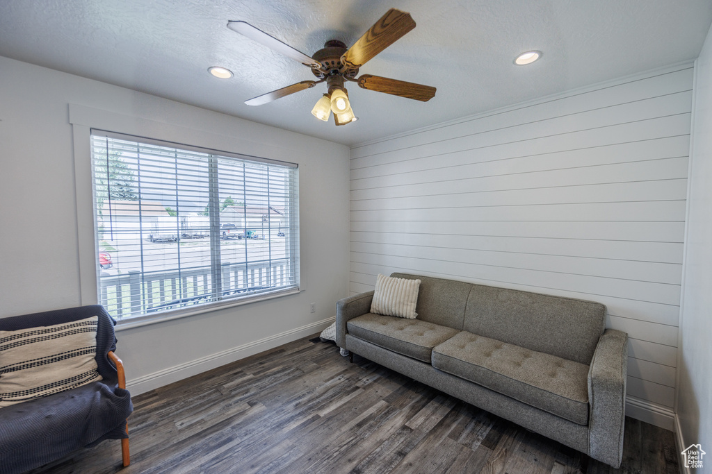 Sitting room with wood finished floors, recessed lighting, a ceiling fan, and wood walls