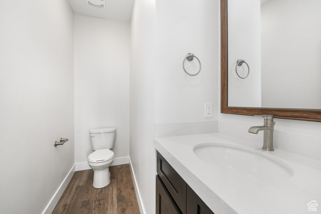 Half bathroom with vanity and wood finished floors