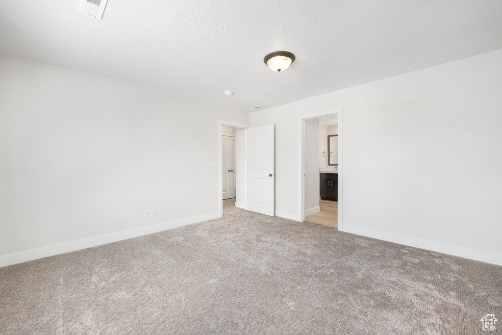 Unfurnished room with light colored carpet and baseboards