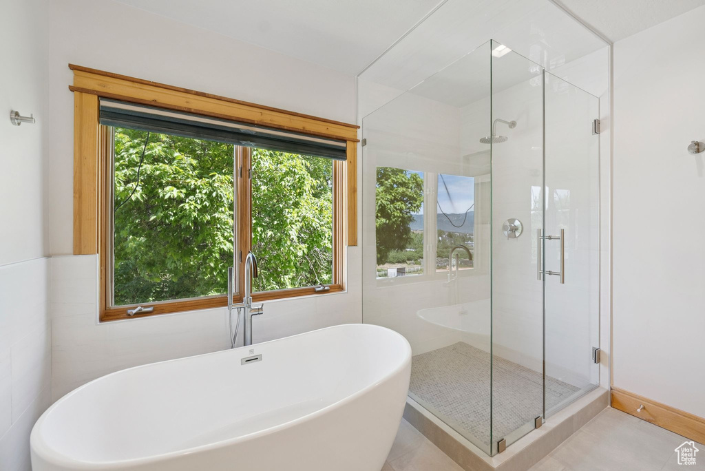 Bathroom with a soaking tub, a stall shower, and tile patterned flooring