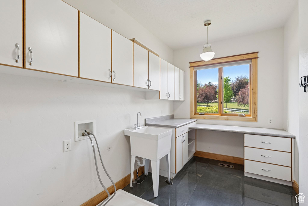 Laundry area with washer hookup, cabinet space, and an office area