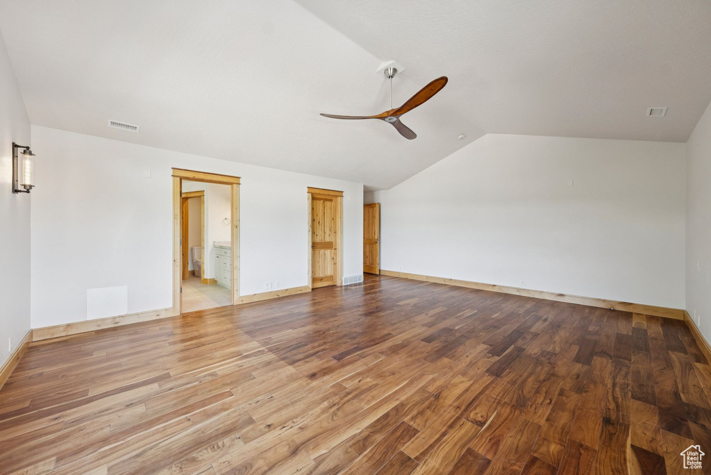 Spare room with lofted ceiling, ceiling fan, and wood finished floors