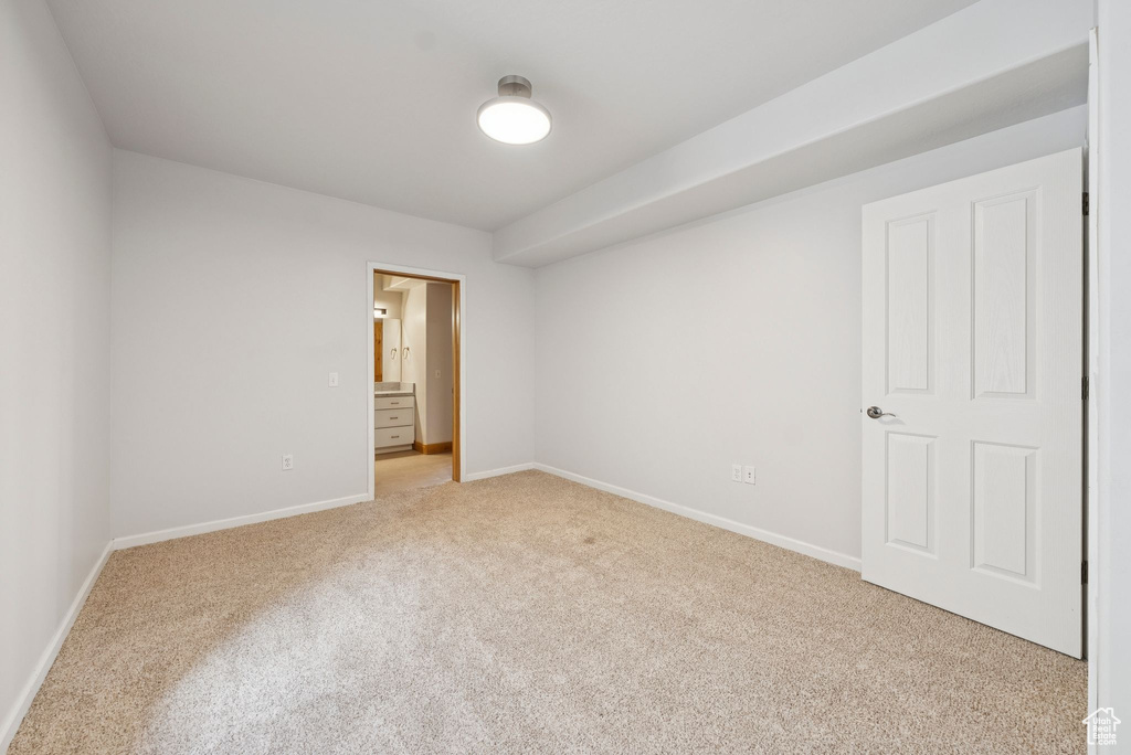 Unfurnished room featuring light colored carpet and baseboards
