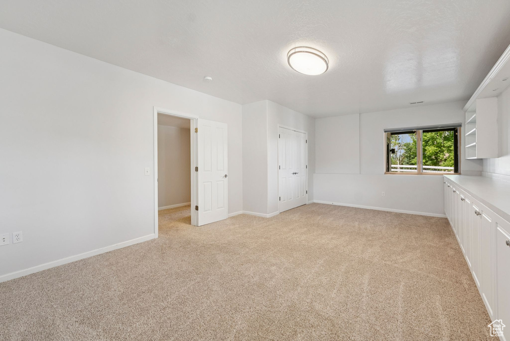 Unfurnished bedroom with light colored carpet