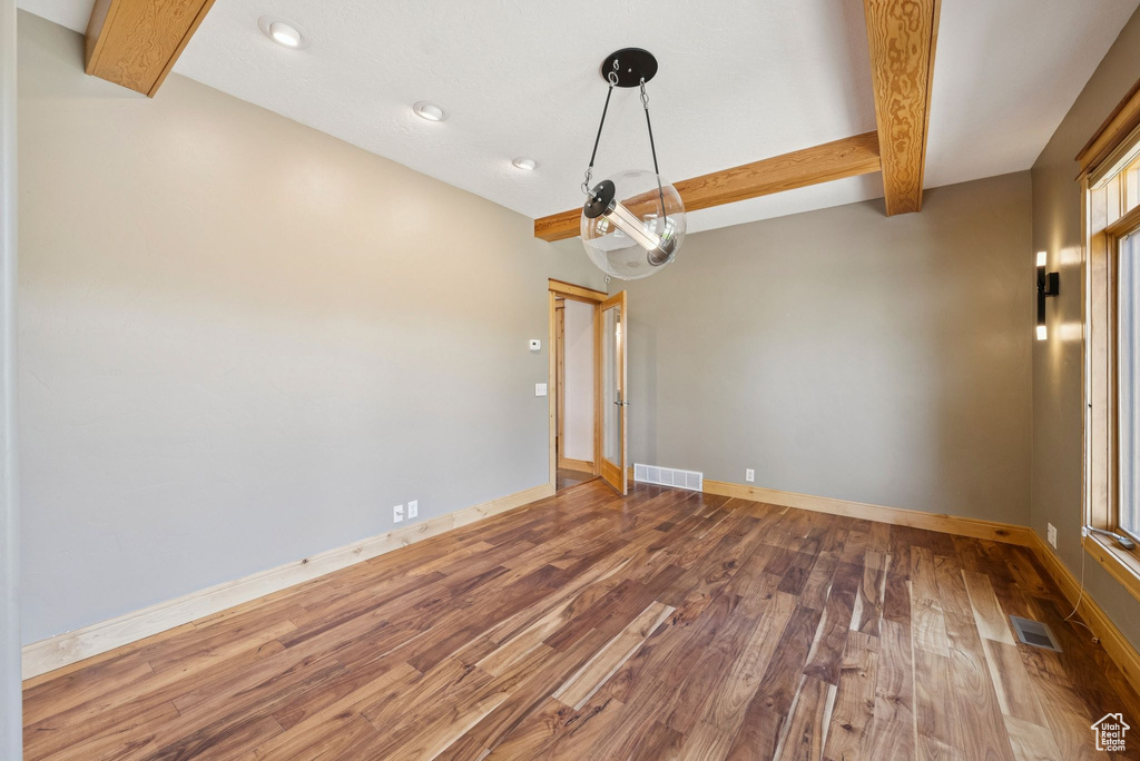 Spare room with beam ceiling, wood finished floors, and recessed lighting
