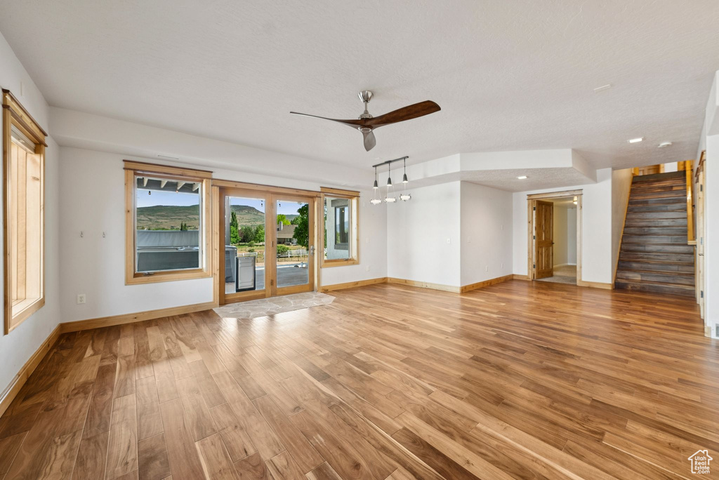 Unfurnished living room featuring a ceiling fan, light wood-style floors, stairway, and recessed lighting