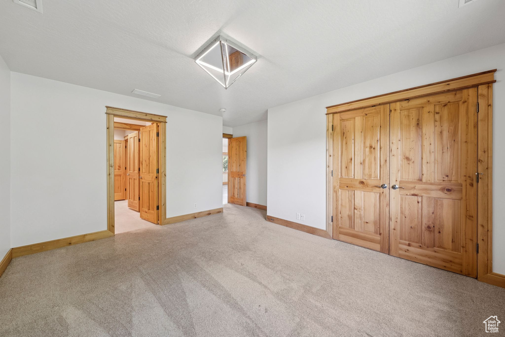 Unfurnished bedroom with carpet and baseboards