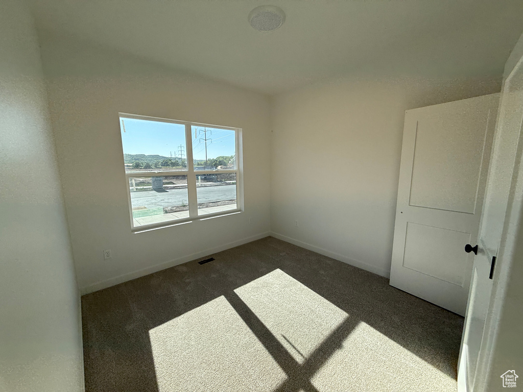 Carpeted empty room featuring baseboards
