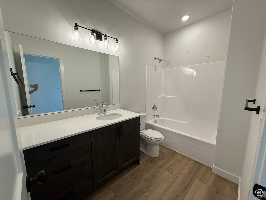Bathroom featuring wood finished floors, vanity, bathtub / shower combination, and recessed lighting