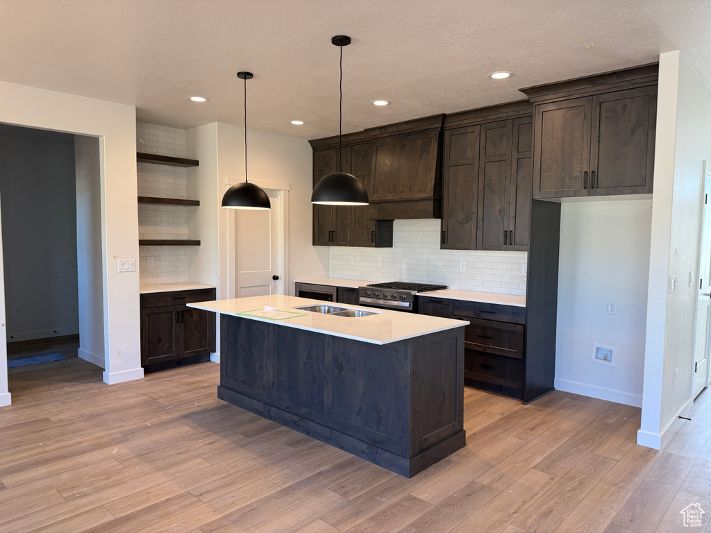 Kitchen with open shelves, dark brown cabinets, decorative backsplash, light wood-style flooring, and recessed lighting