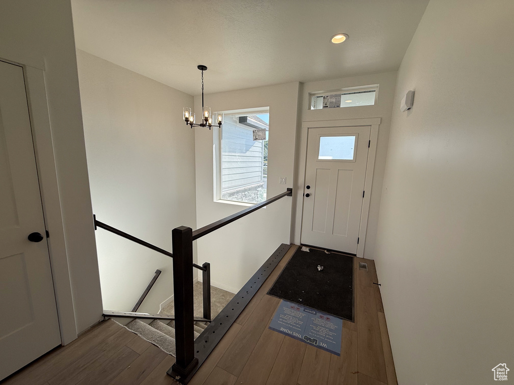 Foyer entrance with wood finished floors, a chandelier, and recessed lighting