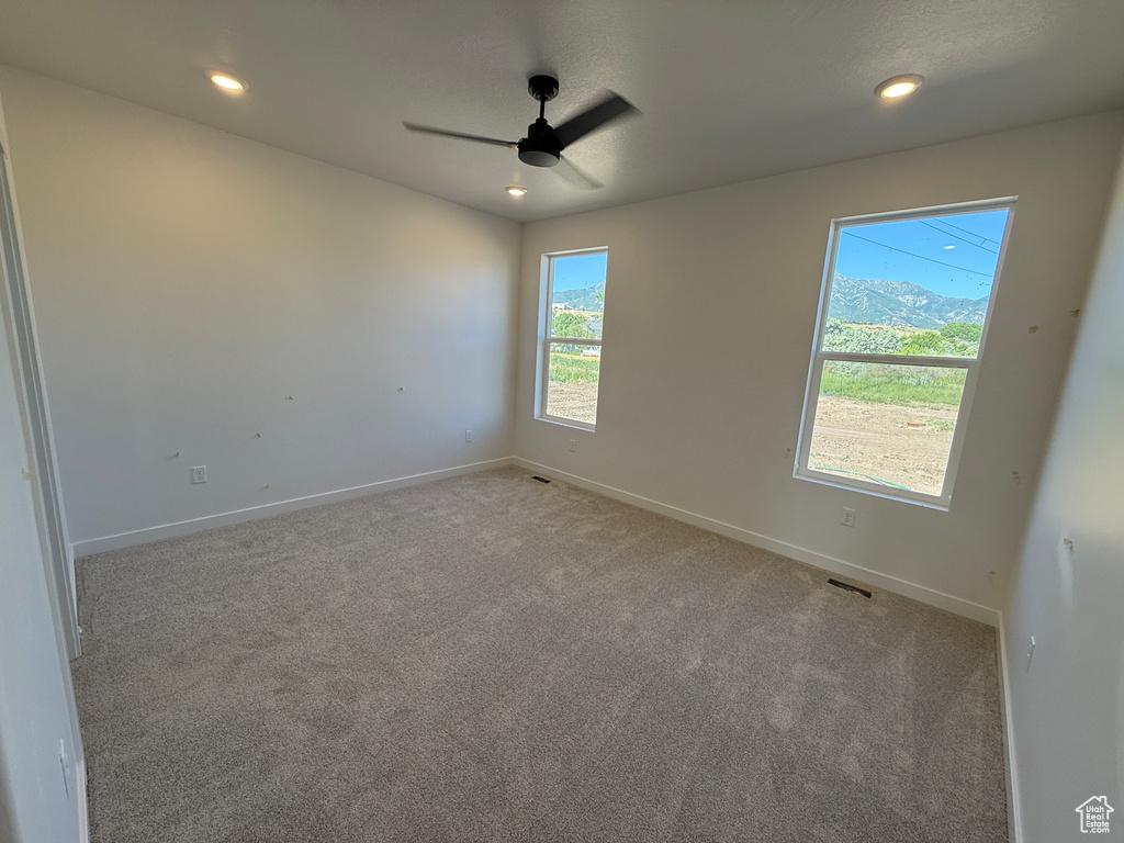 Empty room with a ceiling fan, light carpet, and recessed lighting