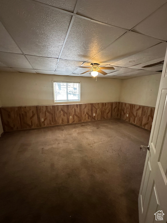 Basement with a drop ceiling and carpet flooring