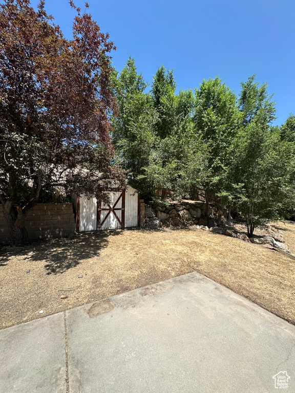 View of yard featuring a shed and a patio