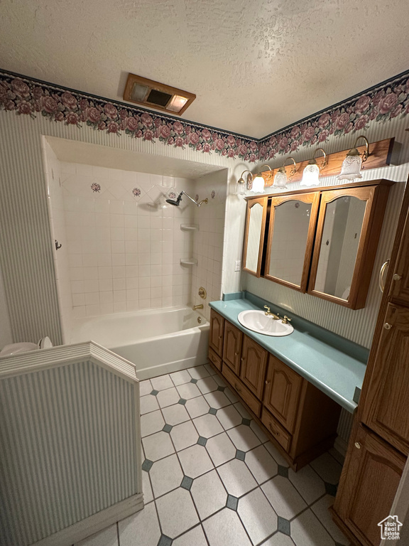 Bathroom with vanity, a textured ceiling, and bathtub / shower combination