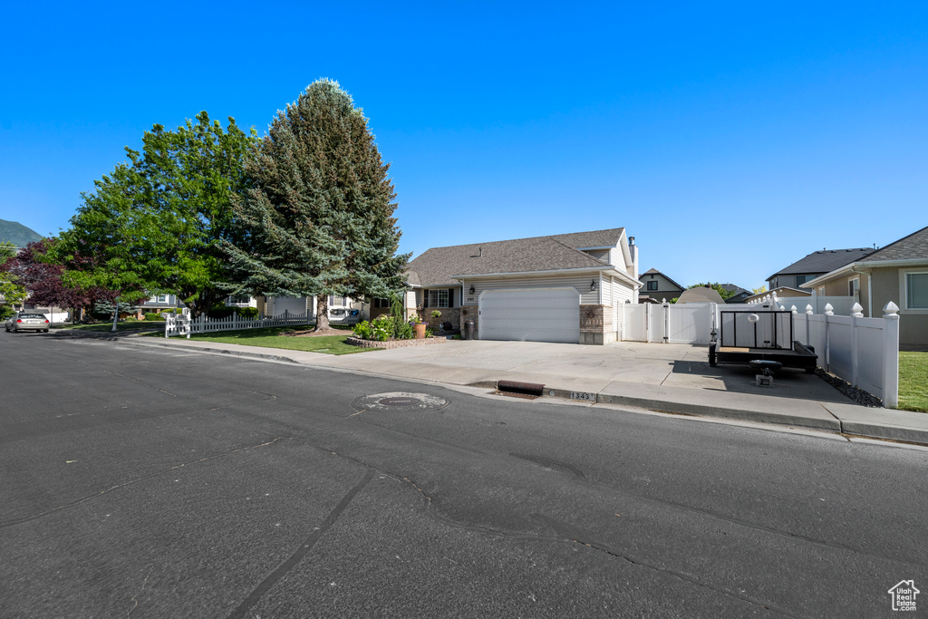 Obstructed view of property with a garage, concrete driveway, and a residential view