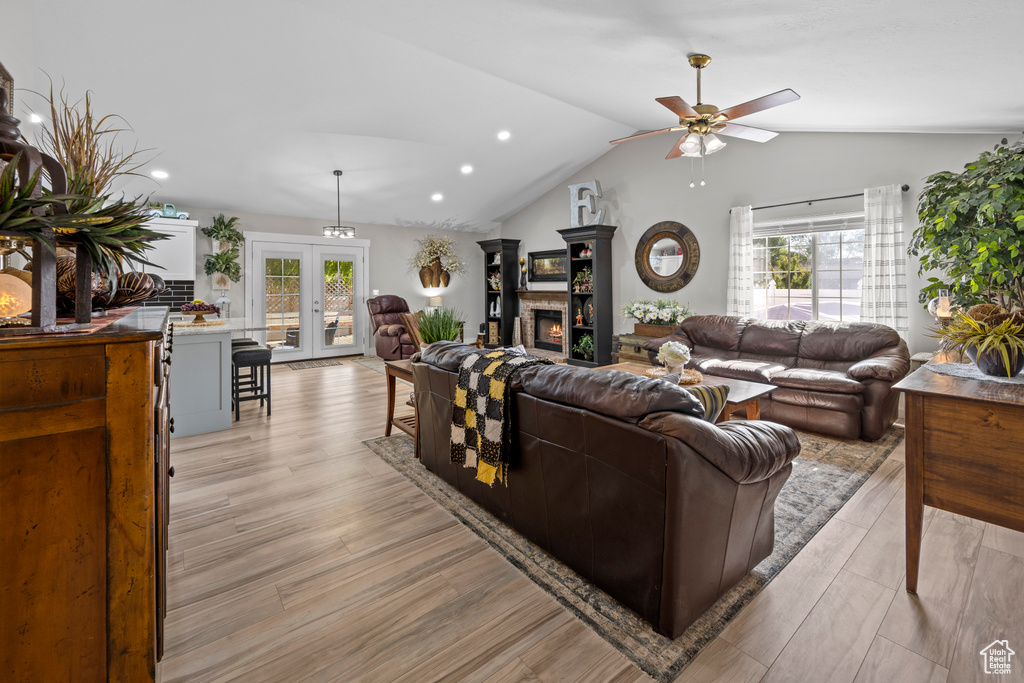 Living room featuring a ceiling fan, lofted ceiling, recessed lighting, light wood-type flooring, and french doors