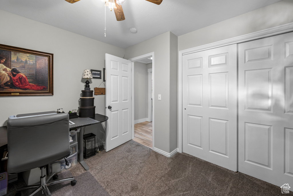 Home office with a ceiling fan and carpet floors