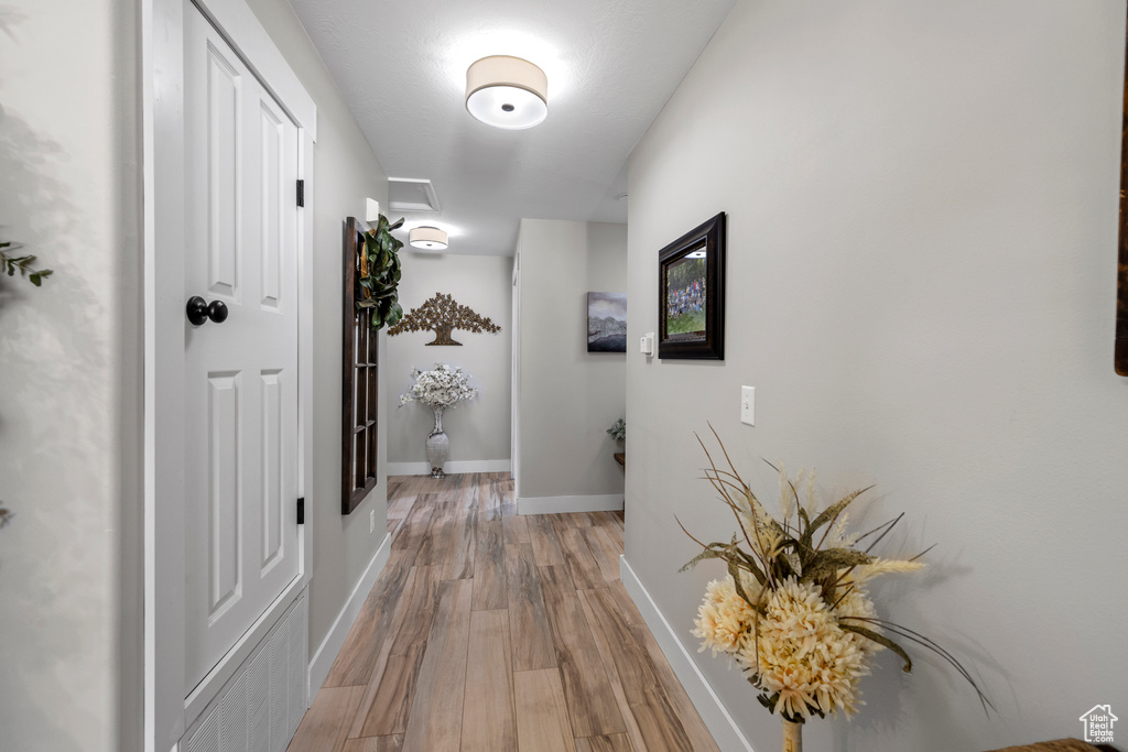 Hall featuring light wood-style floors and baseboards