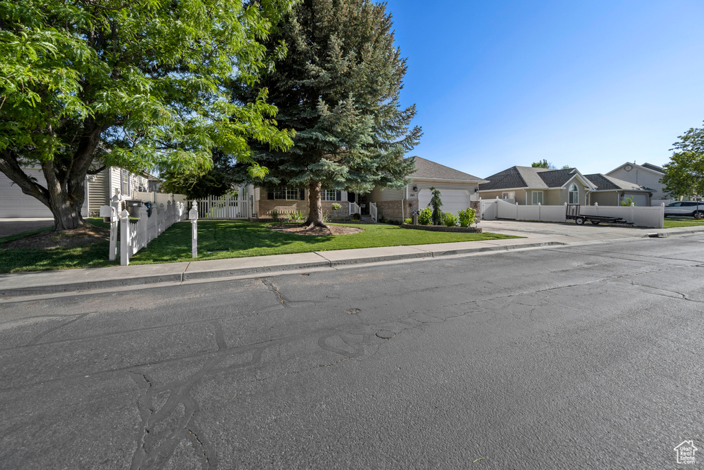 Obstructed view of property featuring driveway, an attached garage, and a residential view
