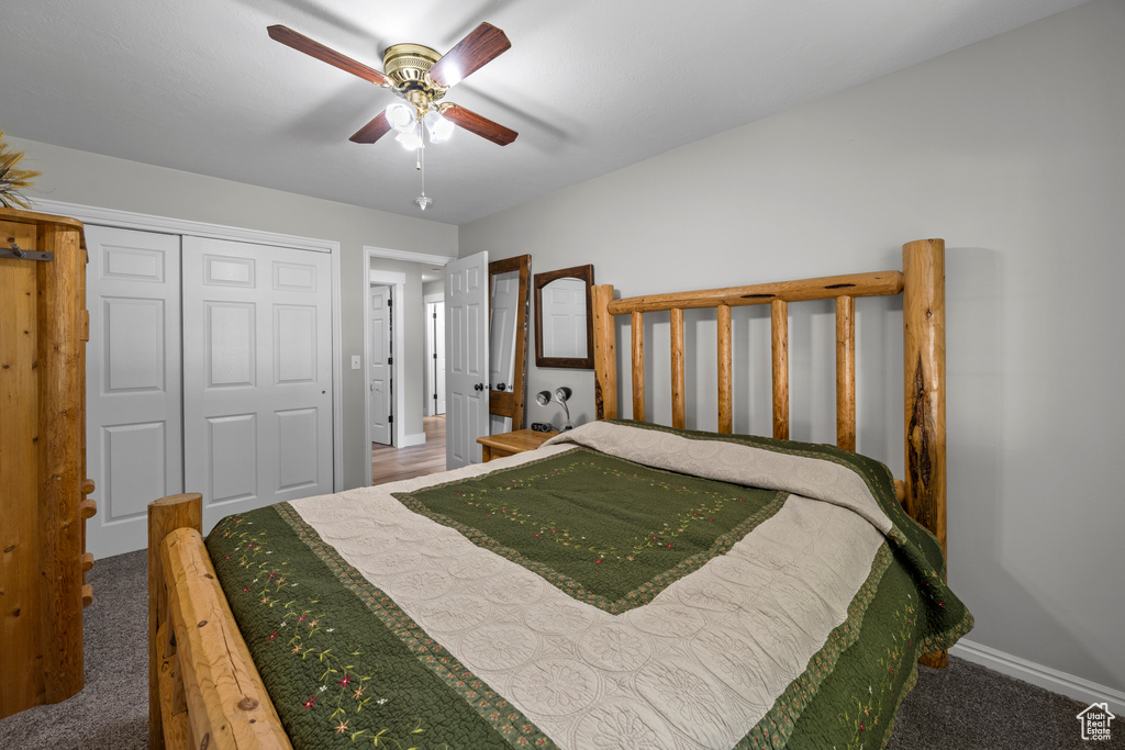 Carpeted bedroom featuring a closet and ceiling fan