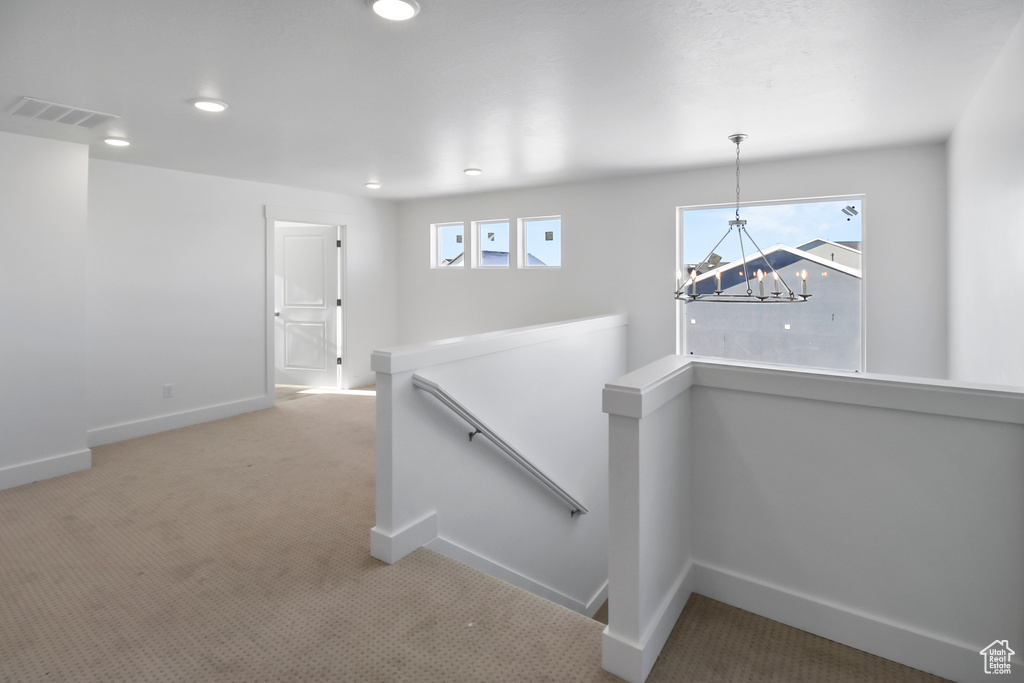 Hallway with an upstairs landing, a chandelier, carpet, and recessed lighting