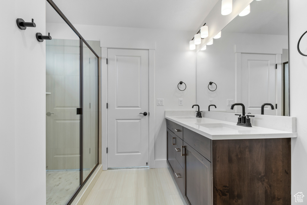 Bathroom featuring double vanity and a shower stall