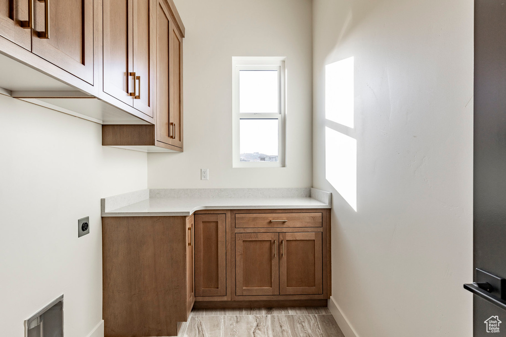 Washroom with electric dryer hookup and cabinet space