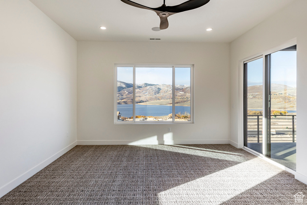 Unfurnished room with carpet, a ceiling fan, recessed lighting, and a mountain view