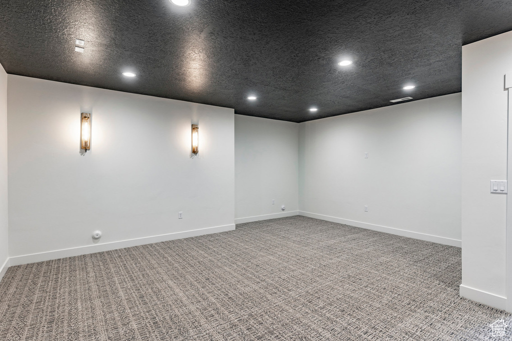 Carpeted empty room featuring recessed lighting