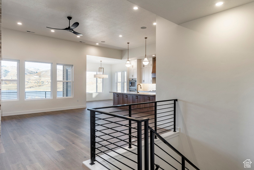 Stairs featuring a ceiling fan, recessed lighting, and wood finished floors