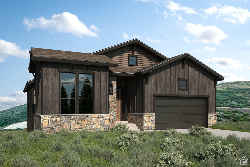 View of front of house with stone siding, driveway, an attached garage, and a shingled roof