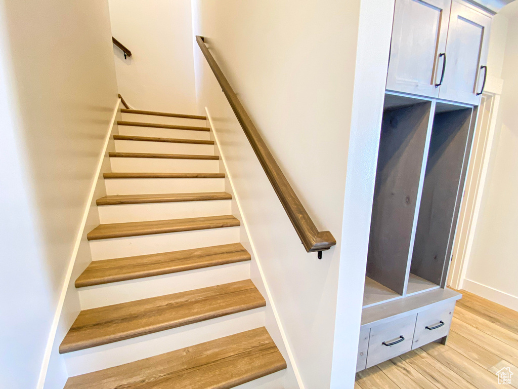 Stairs featuring wood finished floors