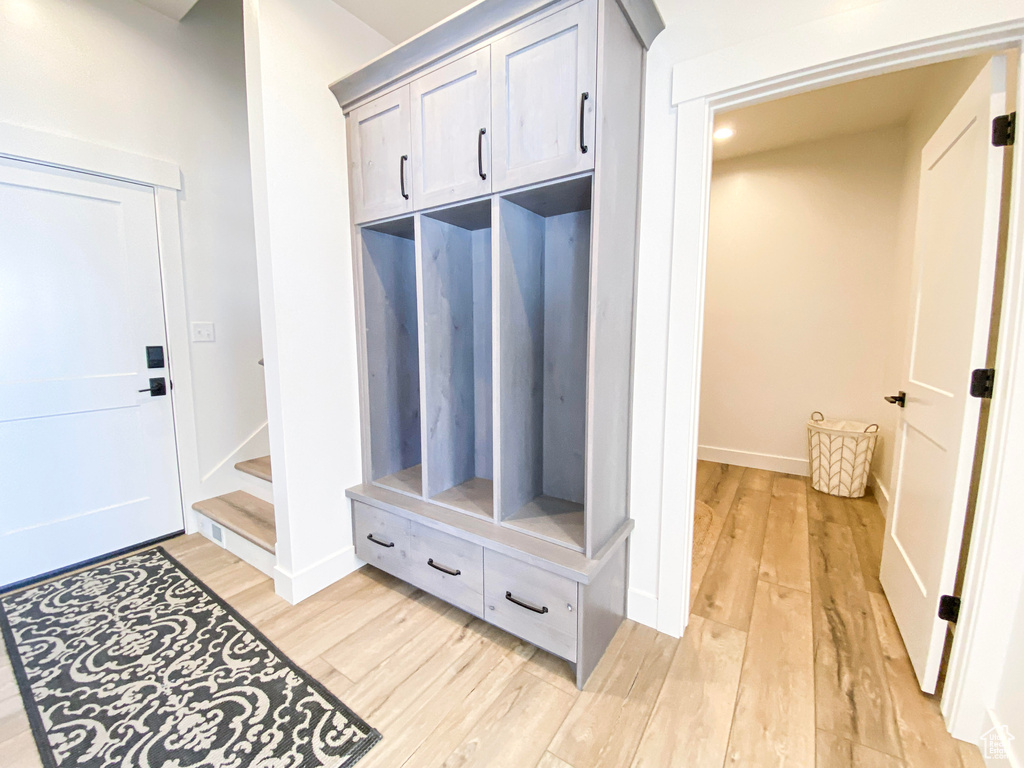 Mudroom with light wood-type flooring and baseboards