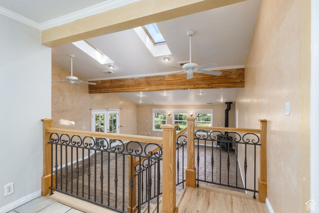 Corridor featuring a skylight, an upstairs landing, and wood finished floors