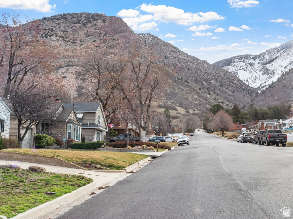 View of asphalt street with a mountain view, curbs, and a residential view