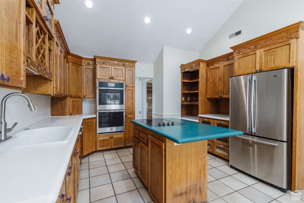Kitchen featuring appliances with stainless steel finishes, open shelves, light tile patterned flooring, decorative backsplash, and vaulted ceiling