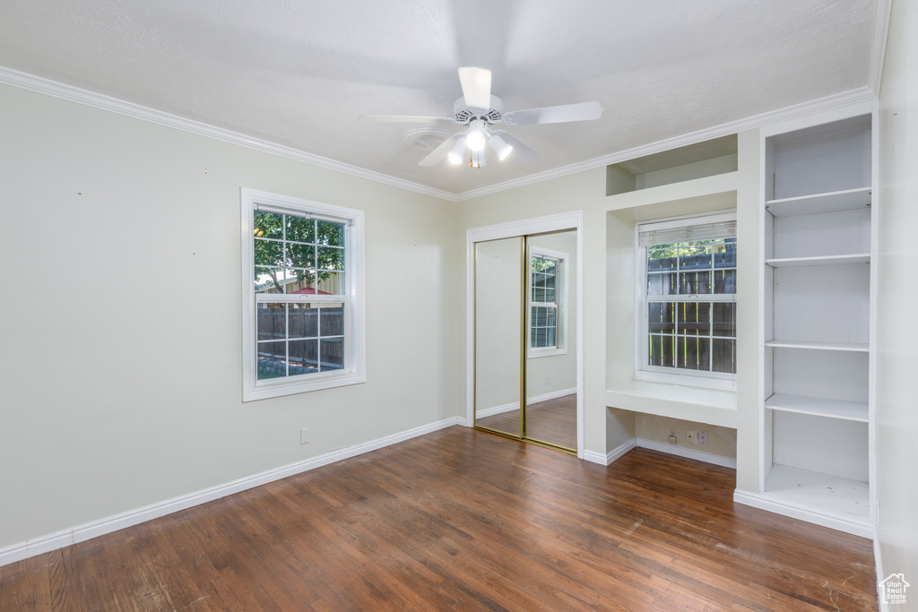 Unfurnished bedroom with wood finished floors, ornamental molding, and ceiling fan
