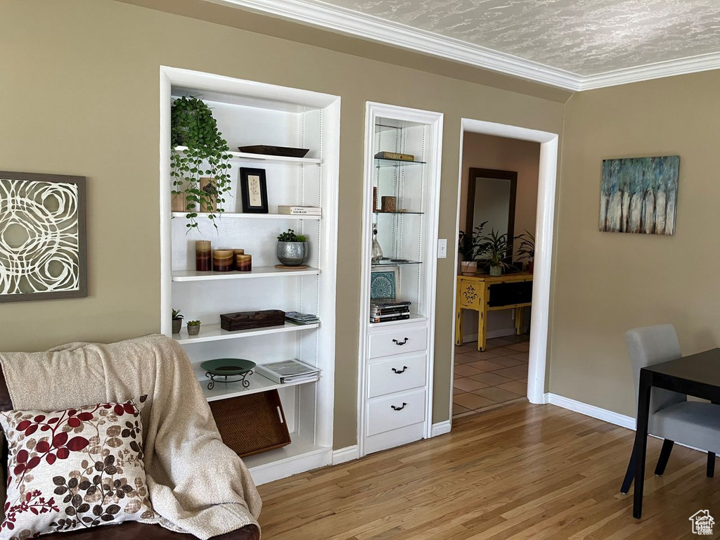Sitting room with wood finished floors and ornamental molding