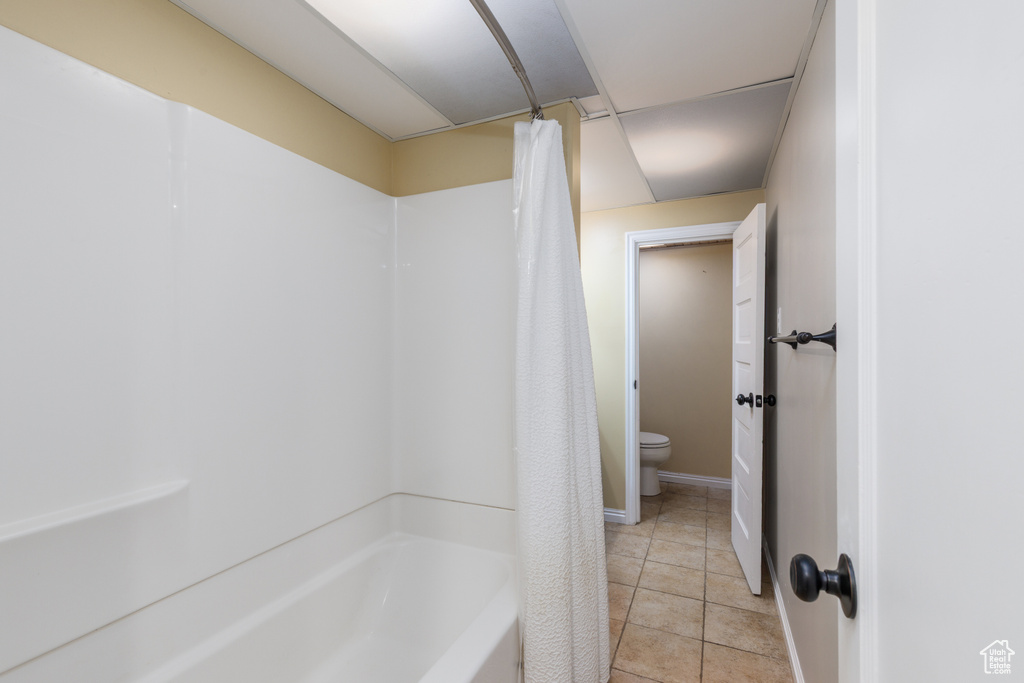 Full bathroom featuring shower / bath combo with shower curtain and tile patterned floors