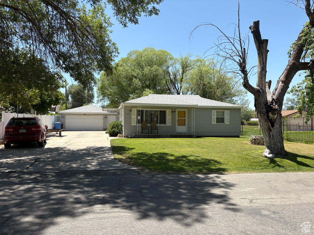 Single story home with a detached garage and roof with shingles