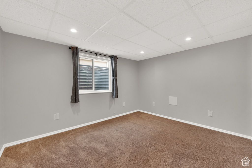 Spare room featuring dark carpet, recessed lighting, and a paneled ceiling