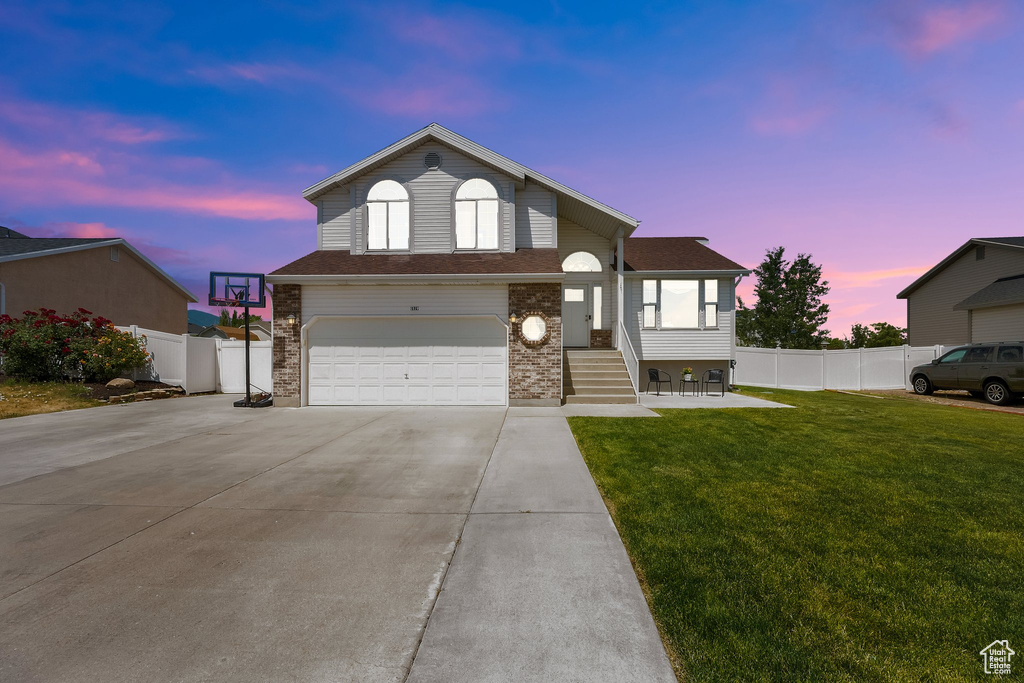 View of front of property featuring a garage, concrete driveway, and brick siding