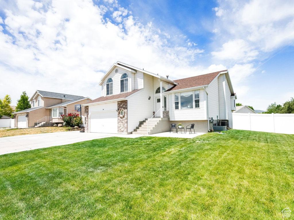 View of front of property with a garage, concrete driveway, stone siding, and entry steps