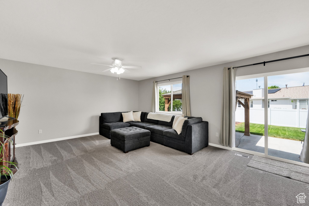 Living room with ceiling fan and carpet