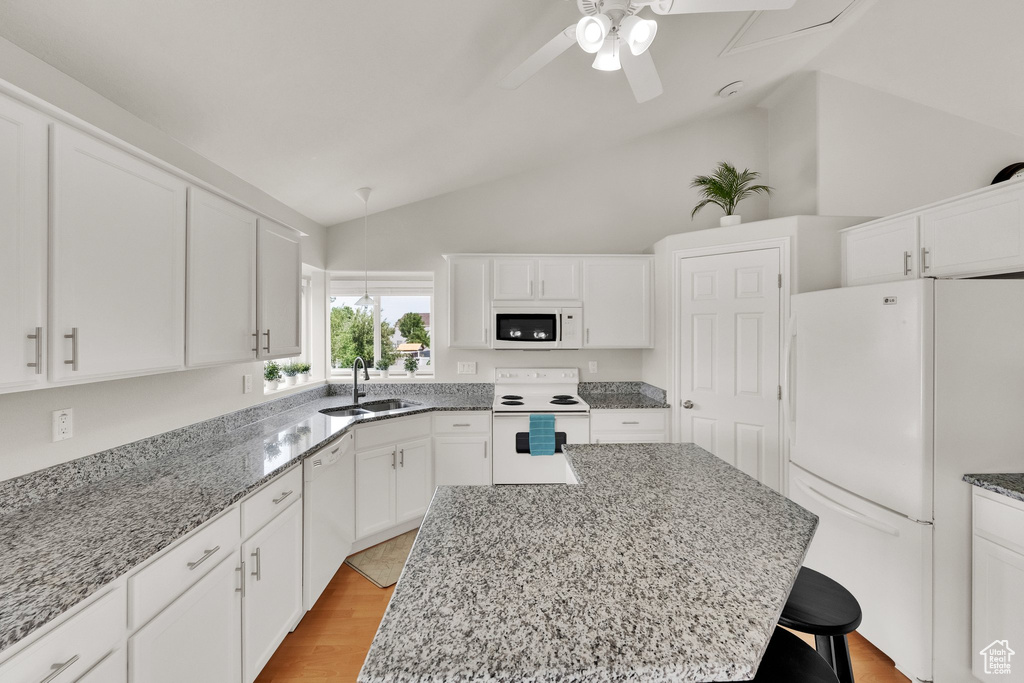 Kitchen featuring white appliances, a ceiling fan, light stone counters, white cabinets, and high vaulted ceiling