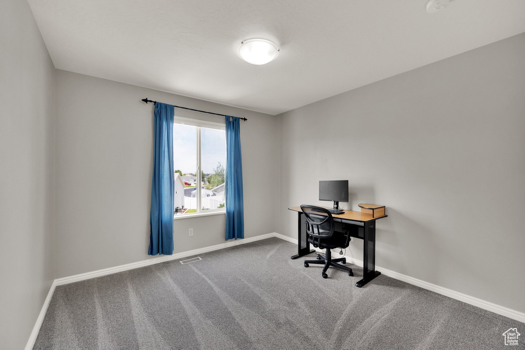 Carpeted office space featuring baseboards